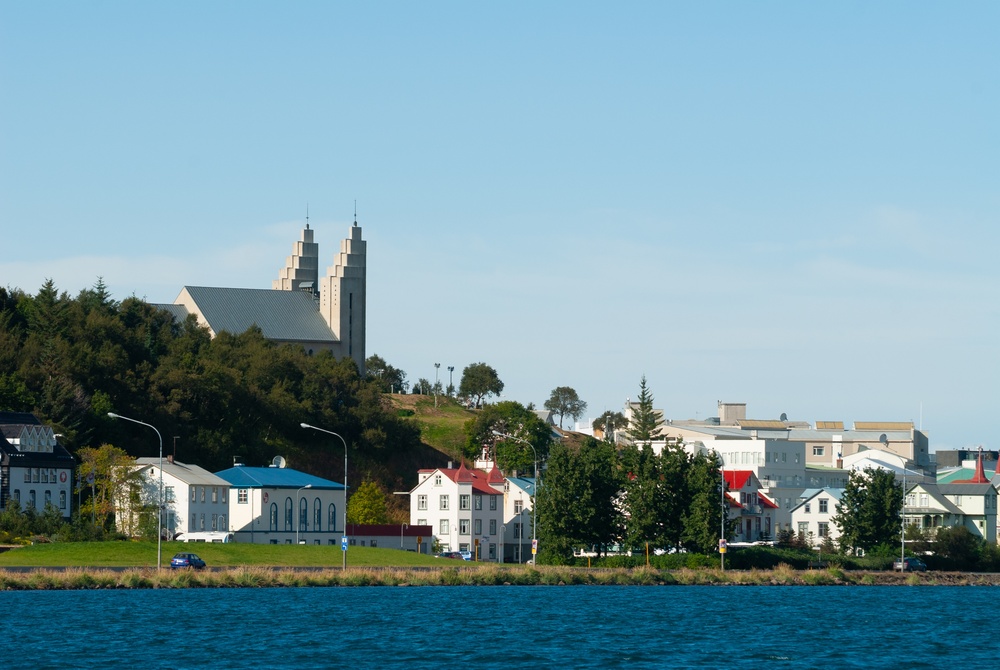Akureyri set over fjorden Eyjafjörður med farvede huse langs vandet og kirken over byen