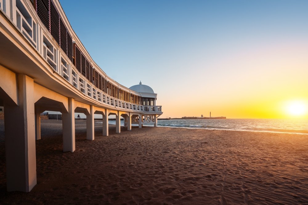 Stranden La Caleta i Cádiz med badehuset Balneario de la Palma ved solnedgang