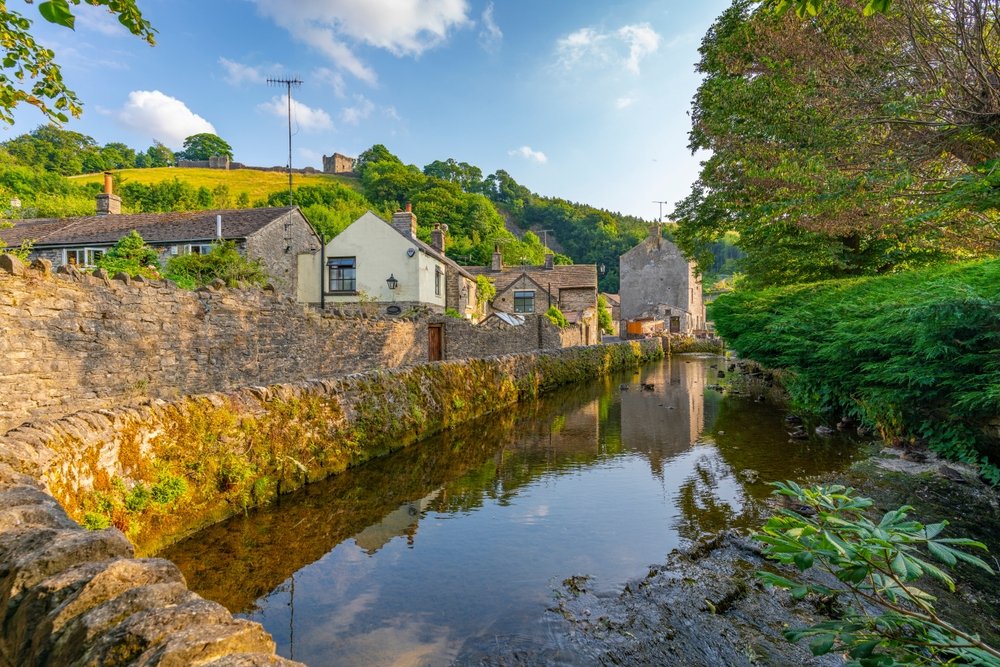 Landsbyen Castleton og bækken med ruinen af Peveril Castle over husene