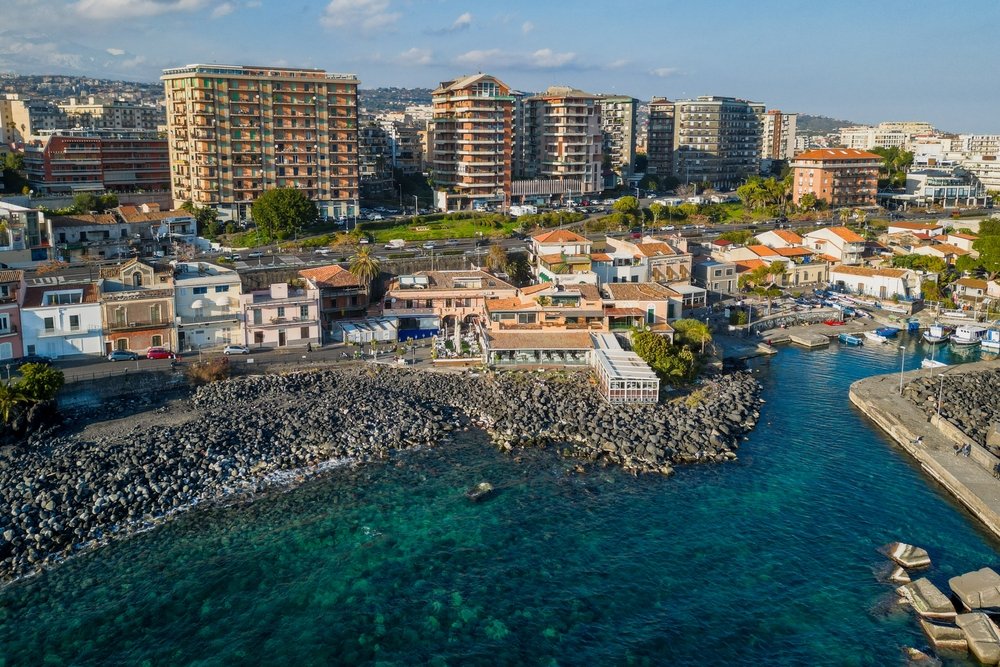 Den lille havn og den sorte lavastrand ved San Giovanni li Cuti i Catania