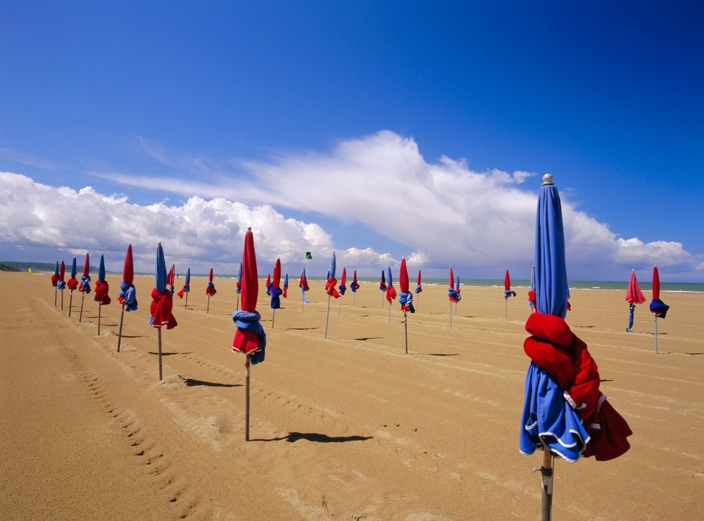 De farvede parasoller på stranden i Deauville i Normandiet