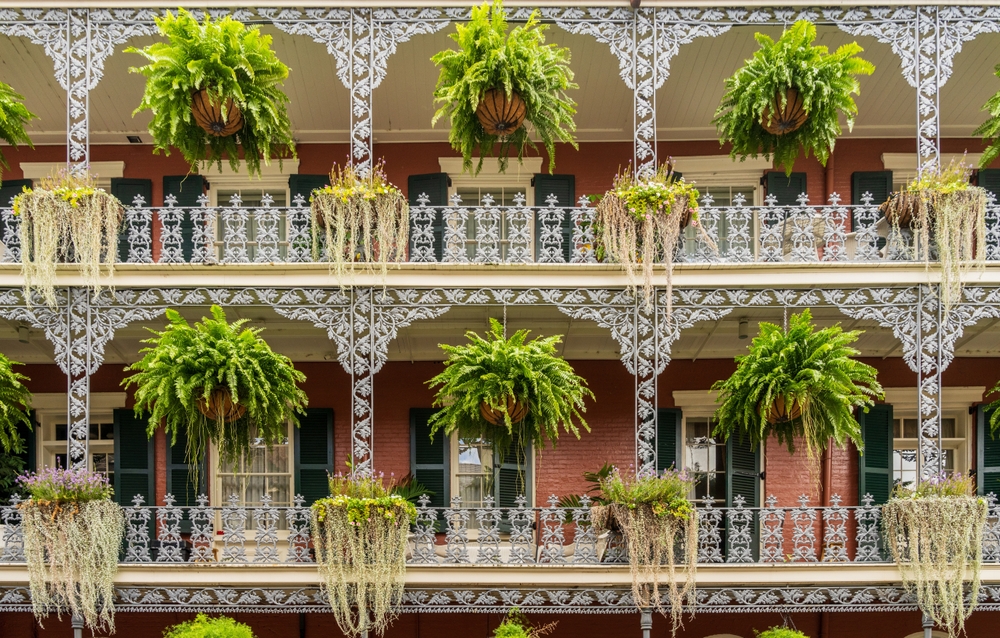 Hus med smedejernsbalkoner og hængende blomsterkurve på Royal Street i French Quarter