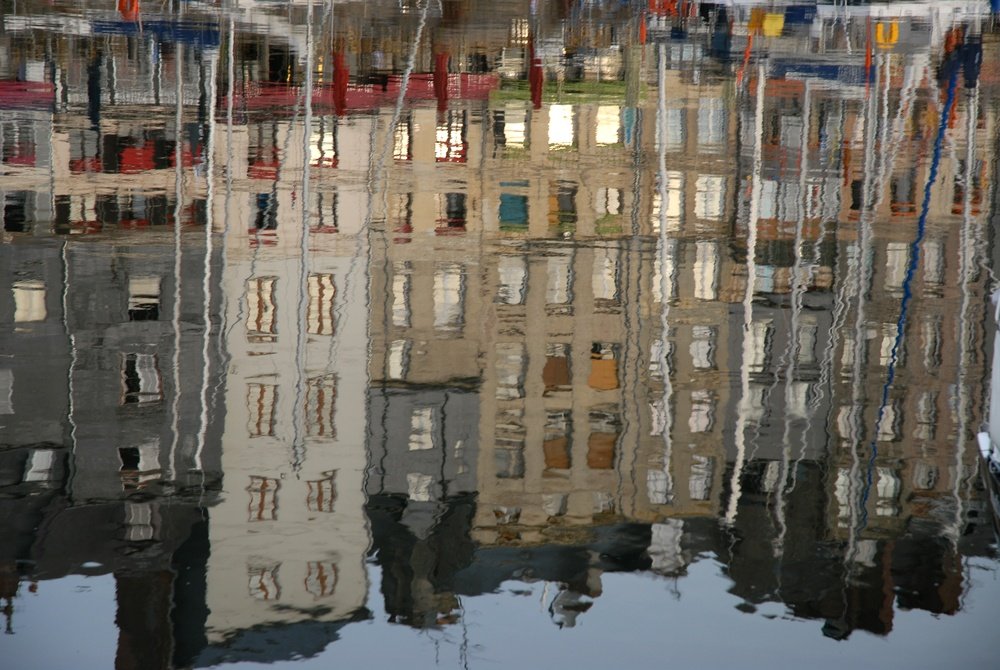 De smalle huse omkring den gamle havn Vieux Bassin i Honfleur spejlet i vandet