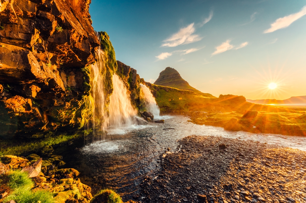 Bjerget Kirkjufell og vandfaldet Kirkjufellsfoss på Snæfellsnes ved solopgang