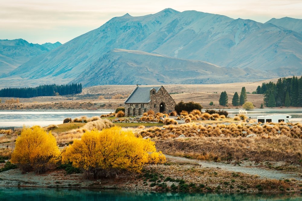 Stenkirken Church of the Good Shepherd ved Lake Tekapo med bjergene bagved