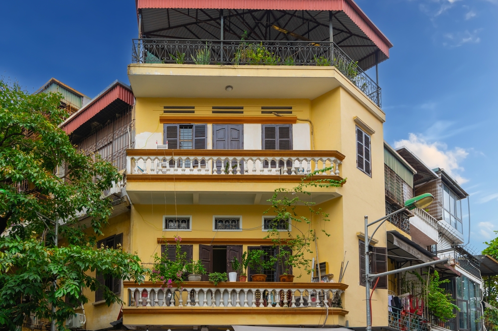 Smalle, høje byhuse med planter på facaden i Old Quarter i Hanoi