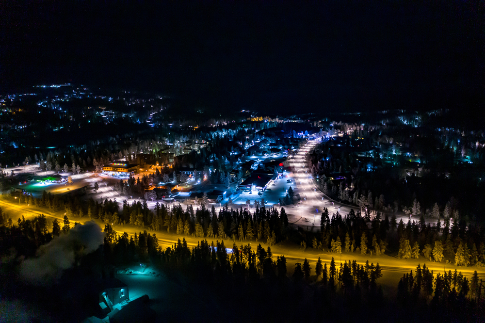 Luftfoto af Saariselkä om aftenen med farverige lys i Lapland
