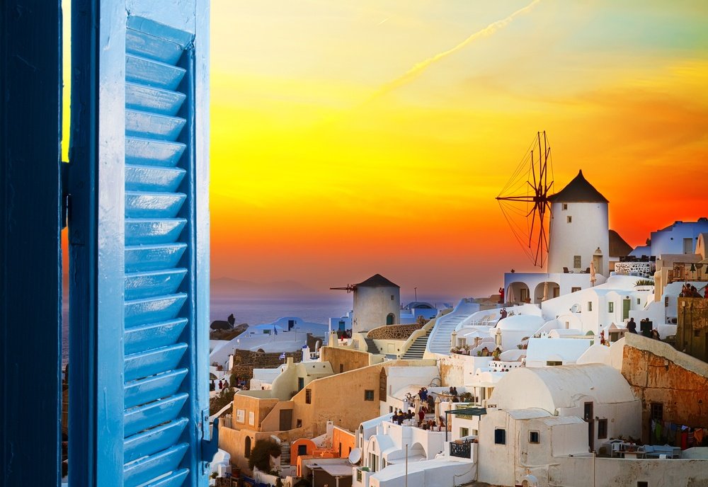 gylden solnedgang i Oia med vindmølle