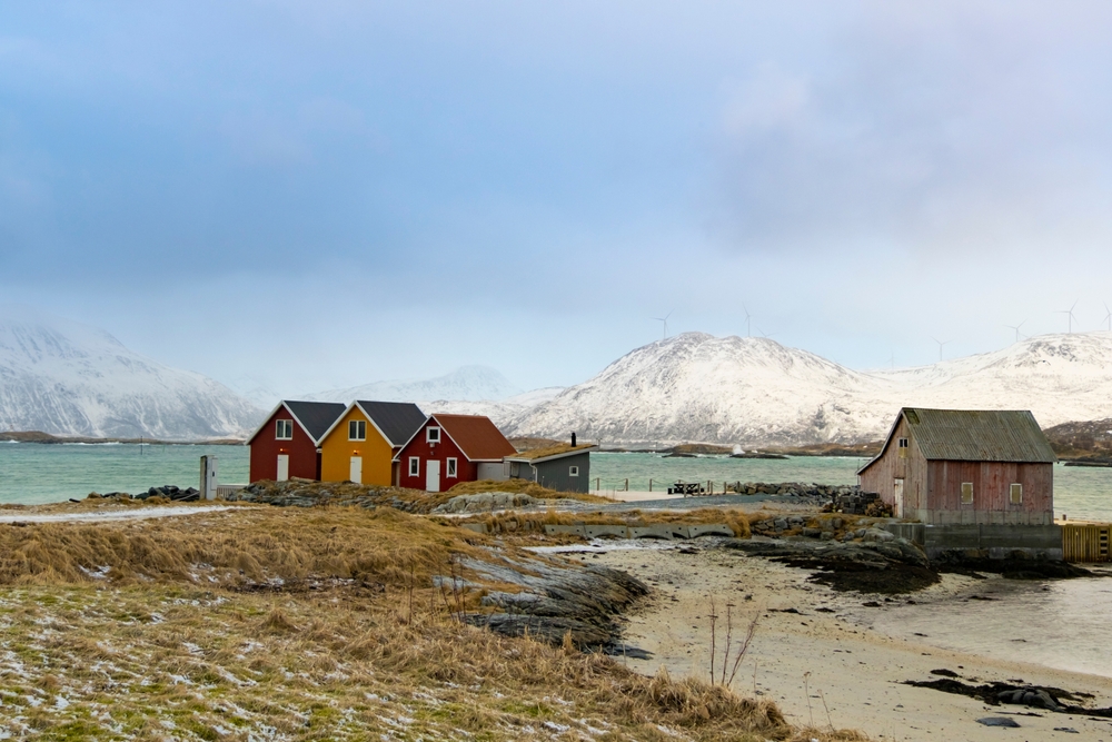 Vinterlandskab på Sommarøy med rorbuer ved vandet