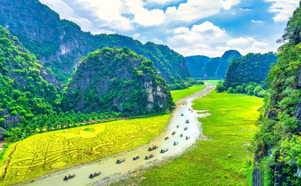 Kalkstensbjerge og rismarker langs Ngo Dong-floden ved Tam Coc i Ninh Binh